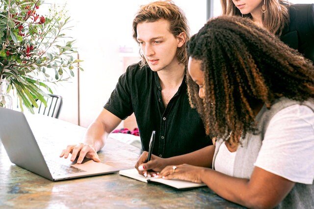 a group of people working on a laptop